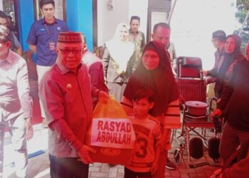 Bupati Gorontalo H. Sofyan Puhi, ST, saat menyerahkan bantuan Asistensi Rehabilitasi Sosial (ATENSI)